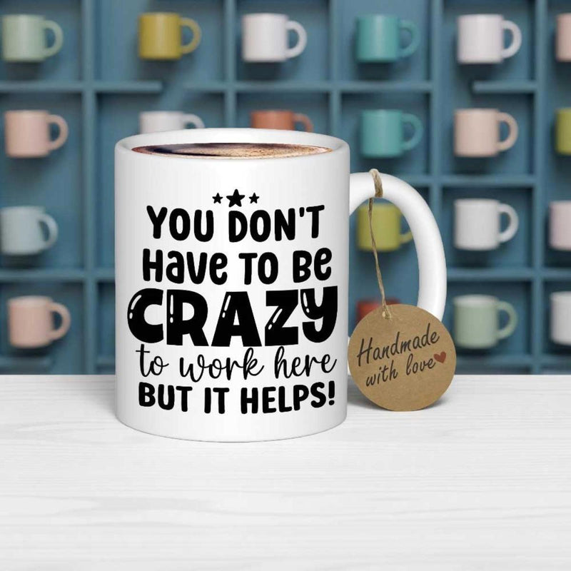Tailorly White Ceramic 11 oz Mug - You Don't Have To Be Crazy To Work Here But It Helps Classic Ceramic Vessel Featuring Bold Black Text And Small Delicate Stars