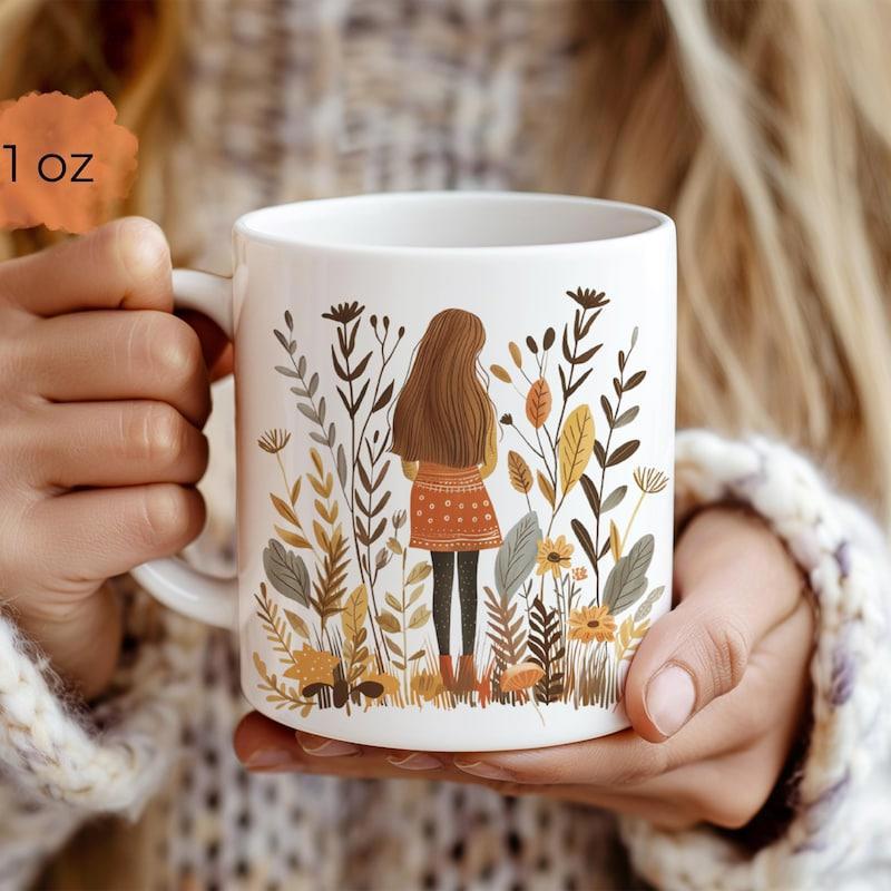 Tailorly White Ceramic 11 oz Mug - Standing Amidst Tall Autumn Botanical Plants With Earthy Colored Wild Floral Girl
