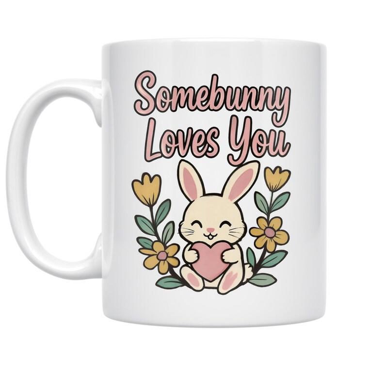 Tailorly White Ceramic 11 oz Mug - Somebunny Loves You Adorable Smiling Rabbit Holding Heart Surrounded By Golden Spring Flowers Bunny