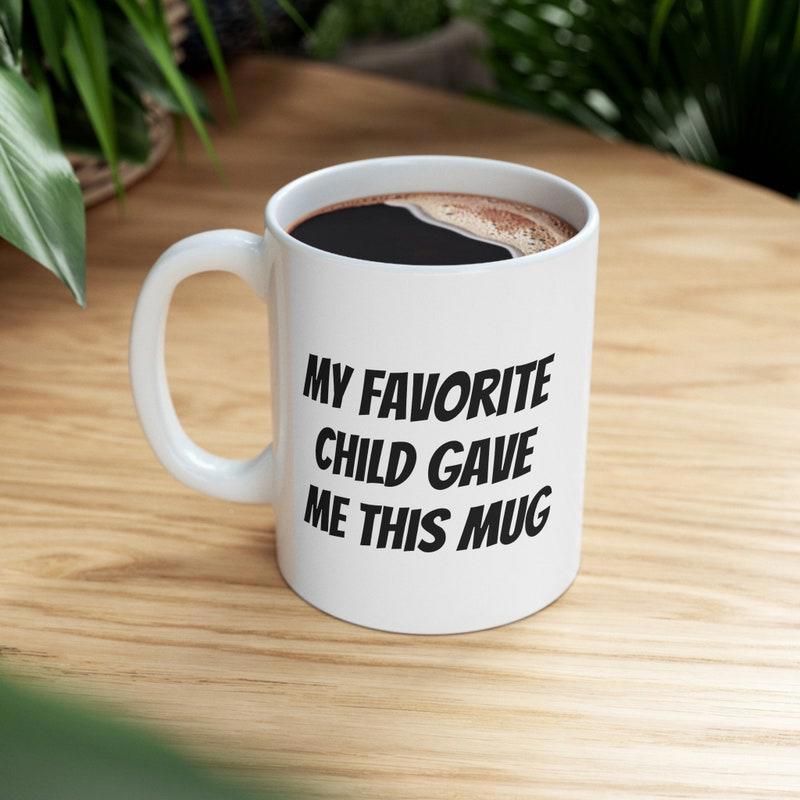Tailorly White Ceramic 11 oz Mug - My Favorite Child Gave Me This Mug Minimalist White Ceramic Vessel Sitting On Natural Grain Wooden Surface Mug