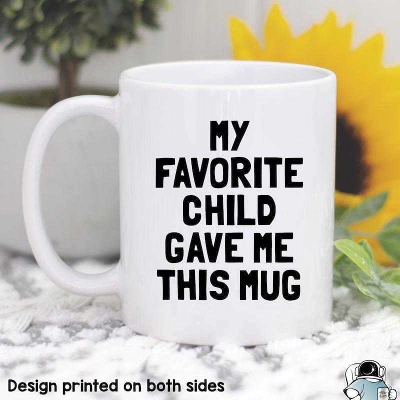 Tailorly White Ceramic 11 oz Mug - My Favorite Child Gave Me This Mug Minimalist White Ceramic Vessel Resting On Soft Textured Surface Mug