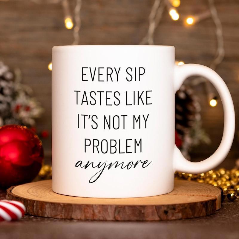 Tailorly White Ceramic 11 oz Mug - Every Sip Tastes Like Its Not My Problem Anymore Minimalist White Ceramic Vessel Resting On Rustic Wooden Coaster Surface Mug