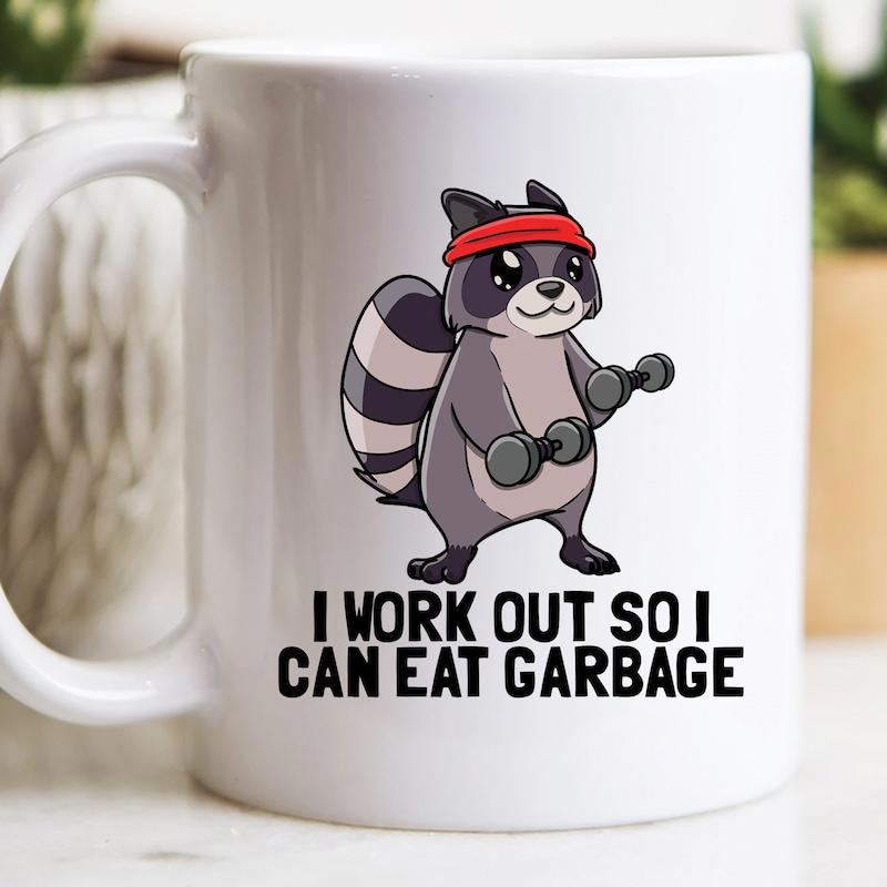 Tailorly White Ceramic 11 oz Mug - I Work Out So I Can Eat Garbage Strong Cartoon Raccoon Wearing Red Headband Lifting Weighted Dumbbells Raccoon