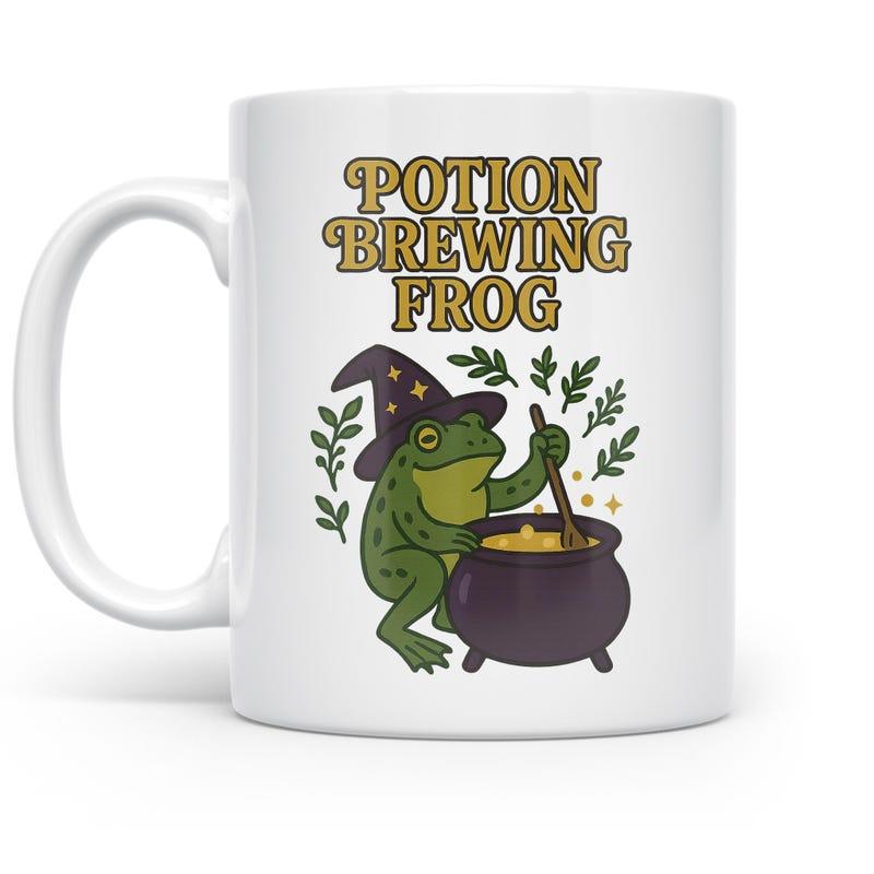 Tailorly White Ceramic 11 oz Mug - Potion Brewing Frog Whimsical Green Creature Stirring A Magical Purple Cauldron Among Twigs Frog