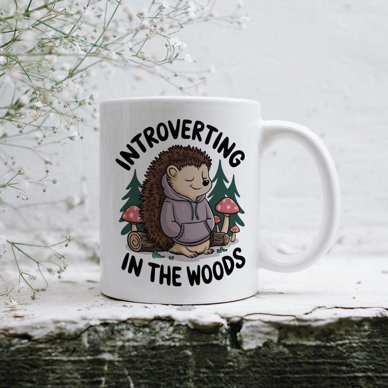 Tailorly White Ceramic 11 oz Mug - Introverting In The Woods Adorable Wildlife Character Wearing Hoodie Sitting Calmly Within Lush Green Forest Hedgehog