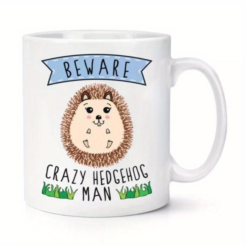 Tailorly White Ceramic 11 oz Mug - Beware Crazy Hedgehog Man Cute Round Animal Standing In Green Grass With Blue Banner Hedgehog