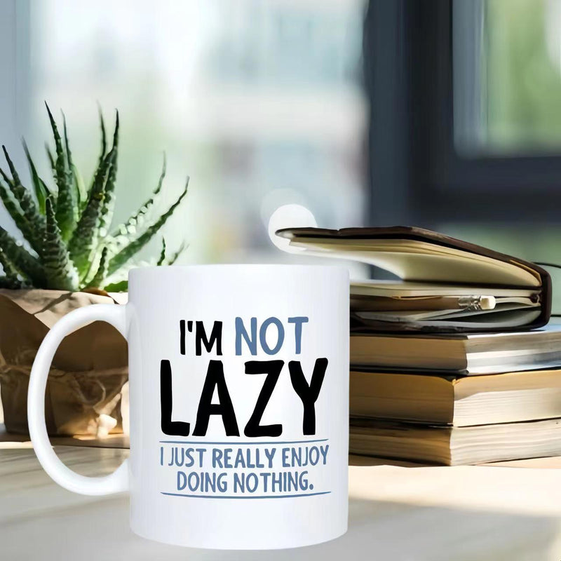 Tailorly White Ceramic 11 oz Mug - Im Not Lazy I Just Really Enjoy Doing Nothing Minimalist Ceramic Vessel Sitting On A Wooden Desk With Stacked Books Mug
