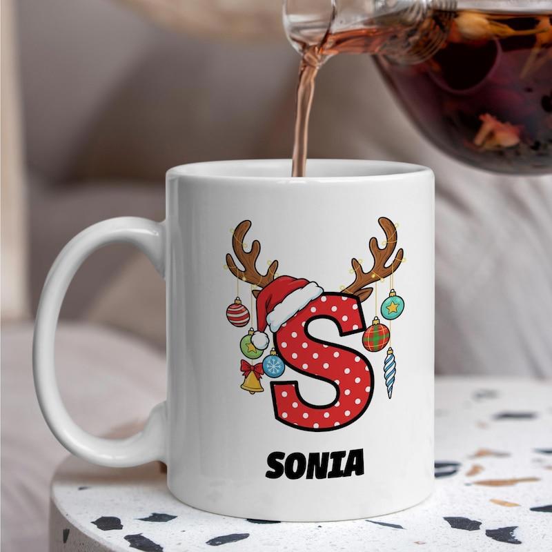 Tailorly White Ceramic 11 oz Mug - Sonia Festive Christmas Reindeer Antlers Wearing Red Santa Hat Among Baubles Letter