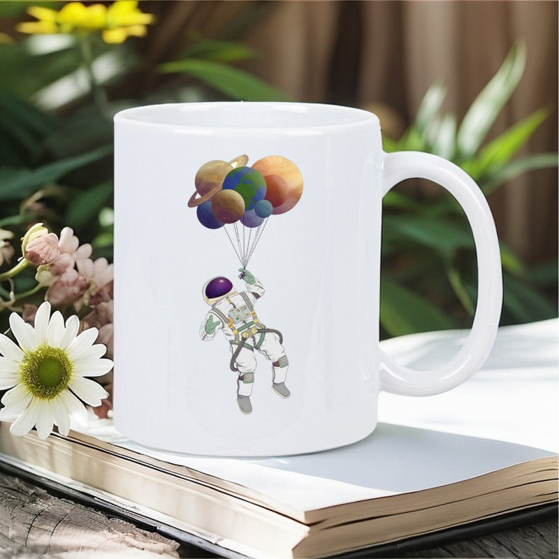 Tailorly White Ceramic 11 oz Mug - Floating In Outer Space Holding Colorful Planet Shaped Balloons Explorer Astronaut