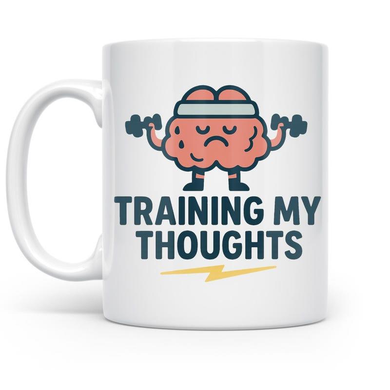 Tailorly White Ceramic 11 oz Mug - Training My Thoughts Cartoon Pink Brain Character Lifting Two Small Black Weights Wearing Headband Brain