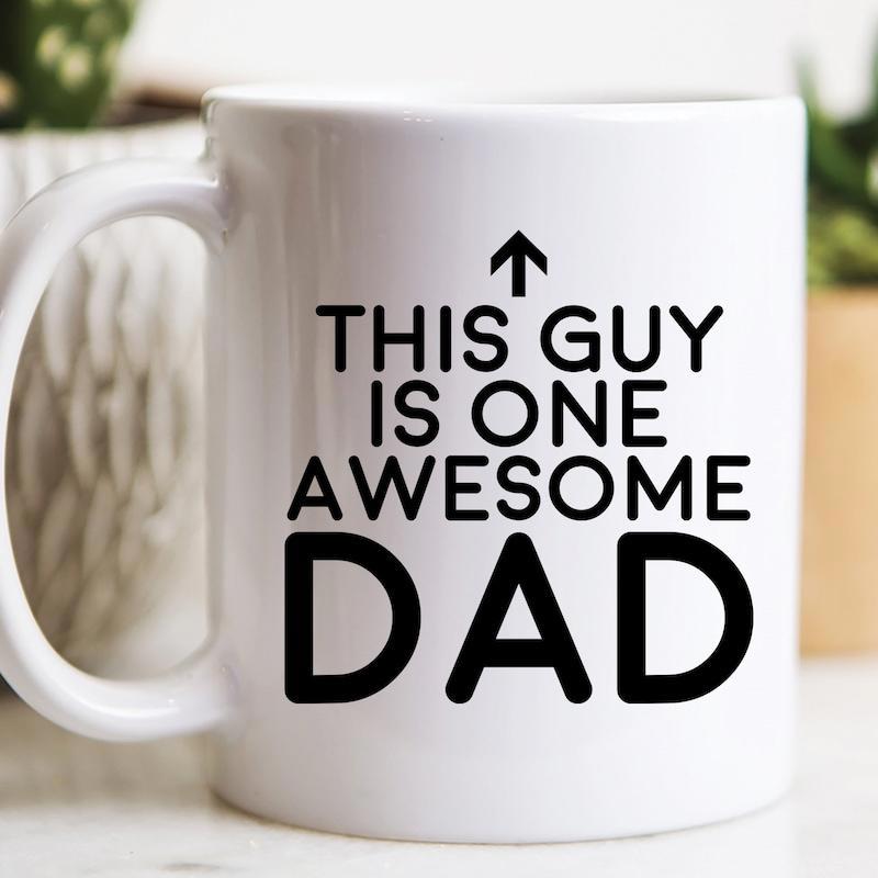Tailorly White Ceramic 11 oz Mug - This Guy Is One Awesome Dad Simple Bold Black Lettering Paired With A Minimalist Small Upward Arrow