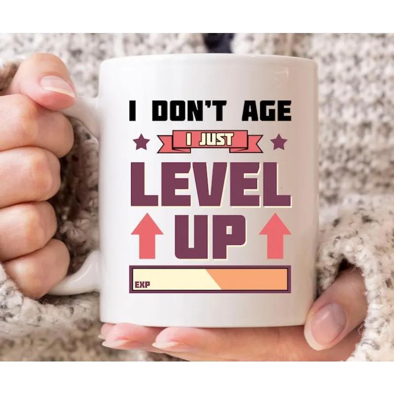Tailorly White Ceramic 11 oz Mug - I Don't Age I Just Level Up Gaming Progress Bar With Upward Arrows And Motivational Star Graphic