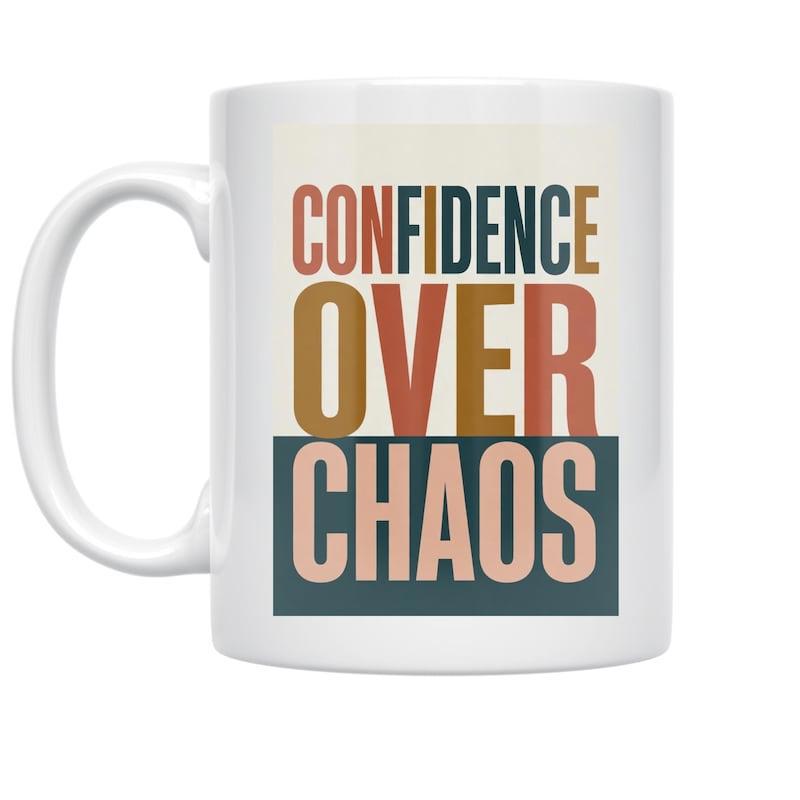 Tailorly White Ceramic 11 oz Mug - Confidence Over Chaos Bold Block Letters In Earth Tones With A Blue Rectangular Base Typography