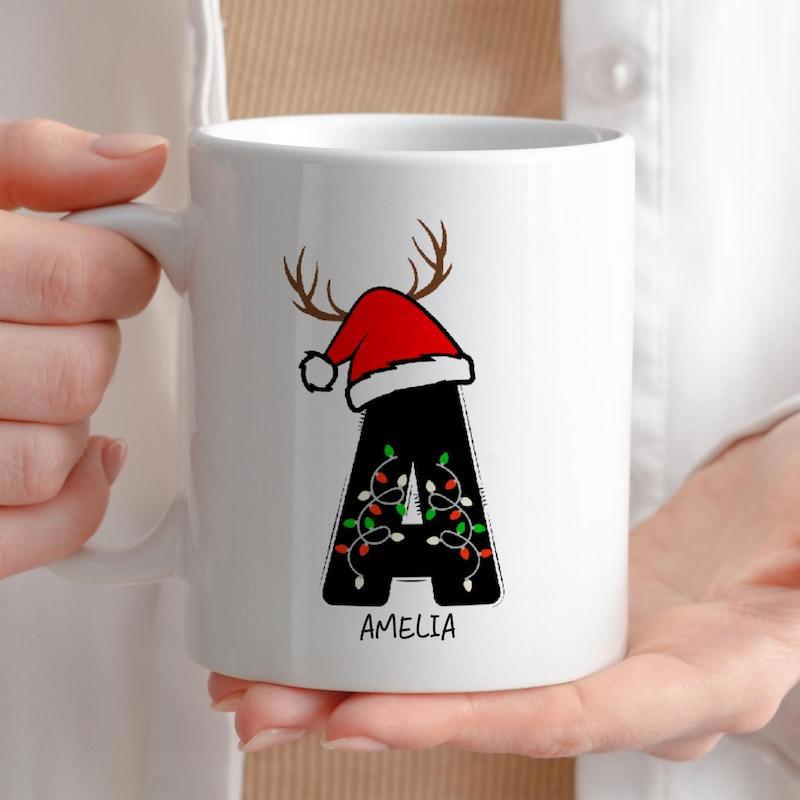 Tailorly White Ceramic 11 oz Mug - Amelia Festive Alphabet Letter With Santa Hat And Reindeer Antlers Among Lights Letter