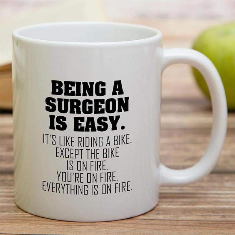 Tailorly White Ceramic 11 oz Mug - Being A Surgeon Is Easy It Is Like Riding A Bike Except The Bike Is On Fire You Are On Fire Everything Is On Fire Bold Black