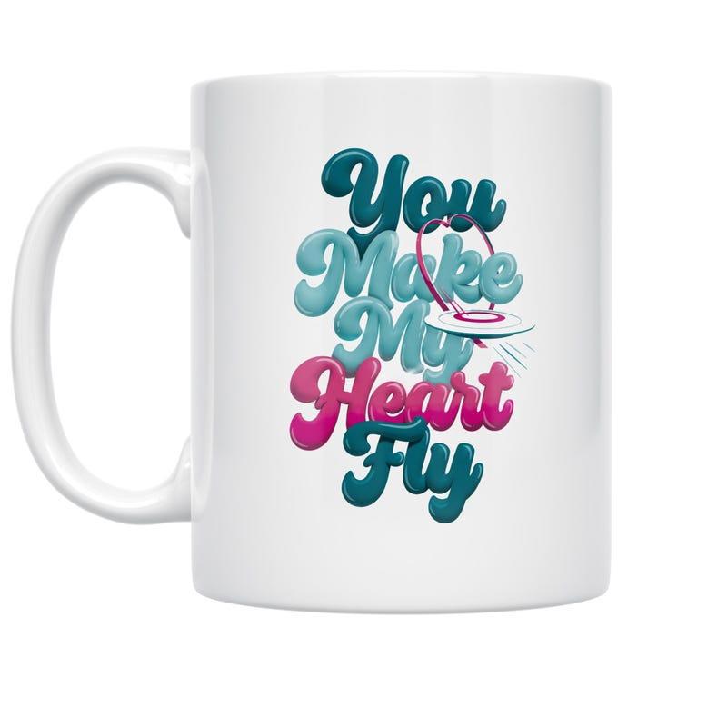 Tailorly White Ceramic 11 oz Mug - You Make My Heart Fly Vibrant Bubbly Three Dimensional Text With Small Flying Saucer Carrying Radiant Heart Mug
