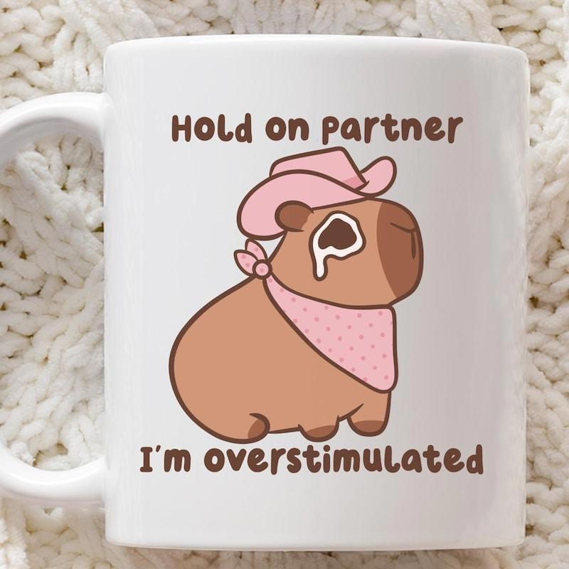 Tailorly White Ceramic 11 oz Mug - Hold On Partner Im Overstimulated Cute Cartoon Capybara Wearing Pink Cowboy Hat And Bandana Capybara