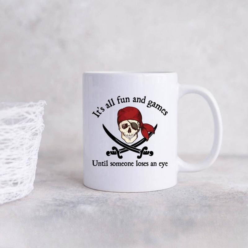 Tailorly White Ceramic 11 oz Mug - Its All Fun And Games Until Someone Loses An Eye Rugged Pirate Wearing Red Bandana With Crossed Swords Behind Its Head Skull