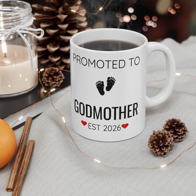 Tailorly White Ceramic 11 oz Mug - Promoted To Godmother Est 2026 Decorative Red Hearts Flanking Tiny Handcrafted Style Baby Footprints