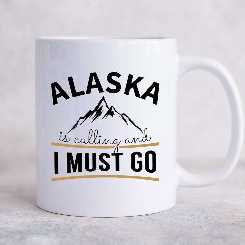 Tailorly White Ceramic 11 oz Mug - Alaska Is Calling And I Must Go Hand Drawn Style Rugged Peaks Under Bold Lettering With Lines Mountain