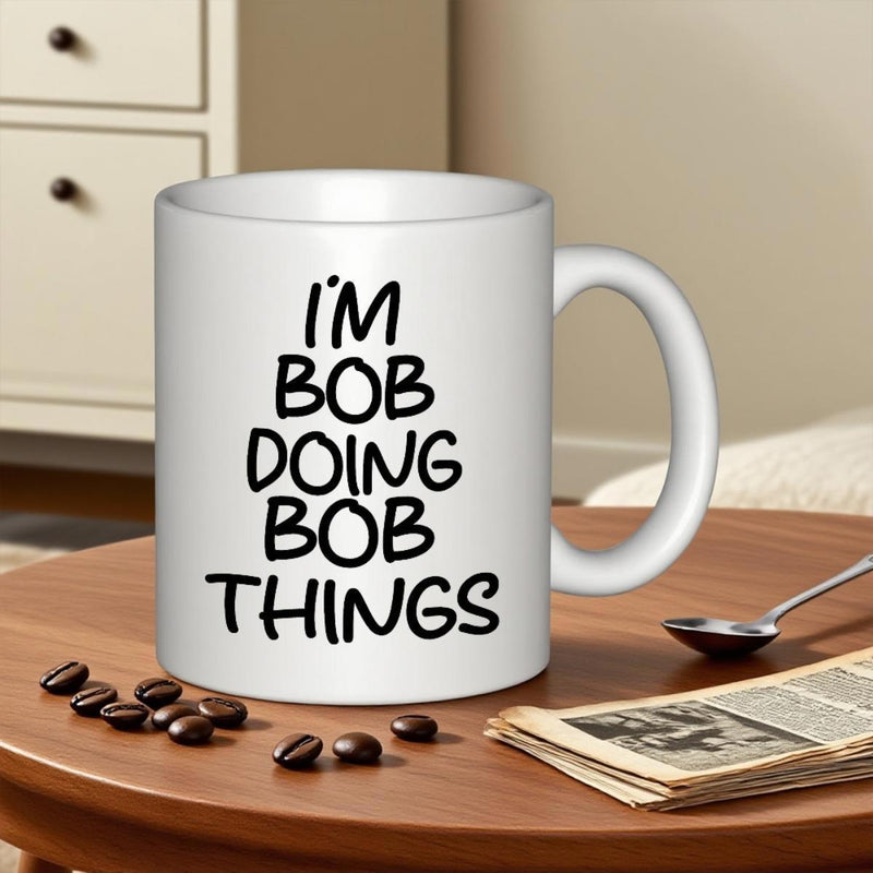 Tailorly White Ceramic 11 oz Mug - Im Bob Doing Bob Things Minimalist White Ceramic Coffee Container Resting On Wooden Table Mug