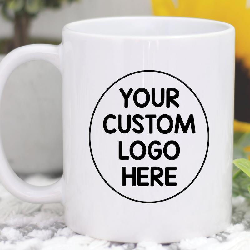 Tailorly White Ceramic 11 oz Mug - Your Custom Logo Here Minimalist Circular Frame Displayed On A Smooth Ceramic Surface Mug