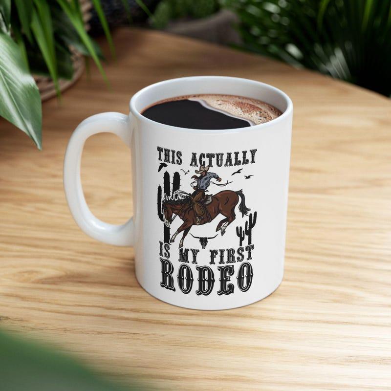 Tailorly White Ceramic 11 oz Mug - This Actually Is My First Rodeo Vintage Style Cowboy Riding Bucking Horse Among Desert Cacti Under Birds Horse