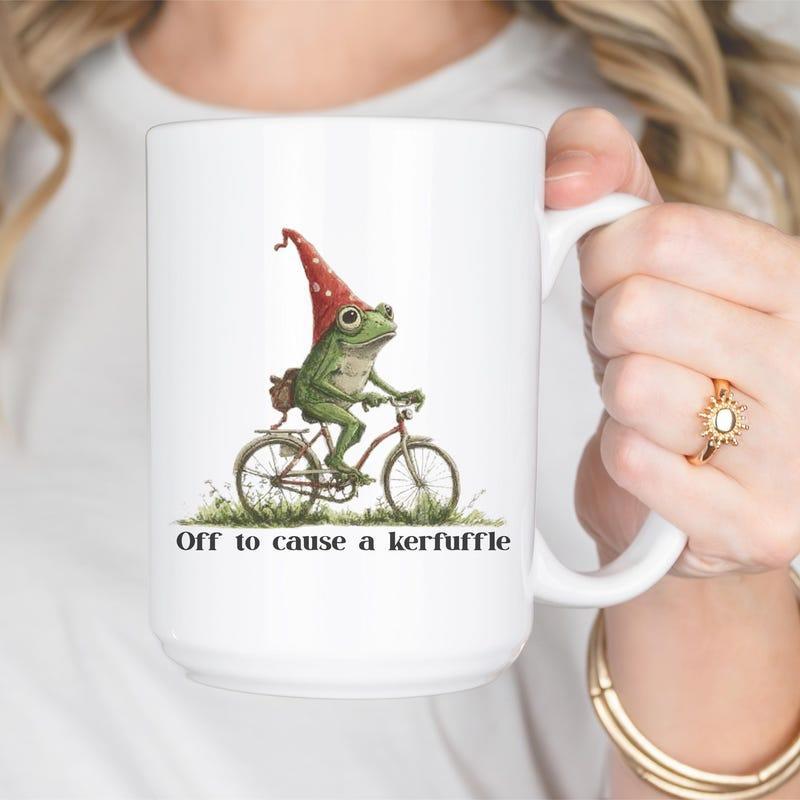 Tailorly White Ceramic 11 oz Mug - Off To Cause A Kerfuffle Whimsical Green Frog Wearing Red Pointed Hat Riding A Bicycle Frog