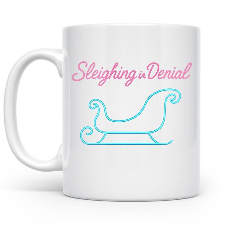 Tailorly White Ceramic 11 oz Mug - Sleighing In Denial Minimalist Blue Silhouette Outlined Floating Over A Simple White Surface Sleigh