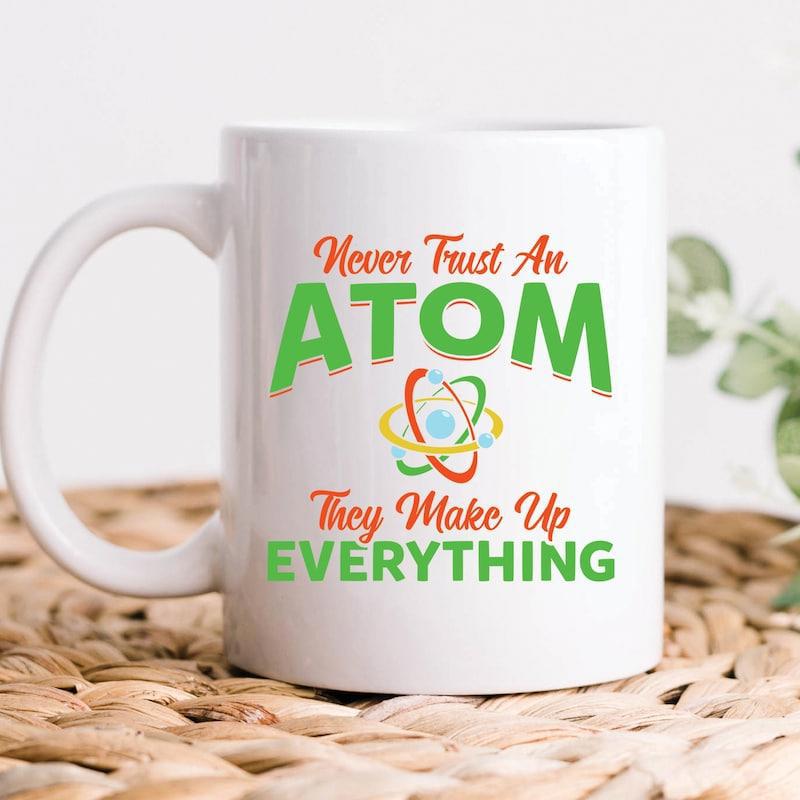 Tailorly White Ceramic 11 oz Mug - Never Trust An Atom They Make Up Everything Colorful Orbits Spinning Around A Core Under A Playful Science Pun Atom