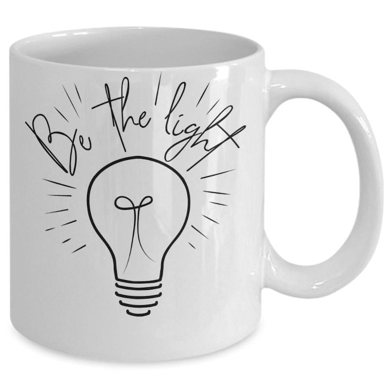 Tailorly White Ceramic 11 oz Mug - Be The Light Minimalist Black Line Art Drawing With Radiating Rays Surrounding A Glowing Lightbulb