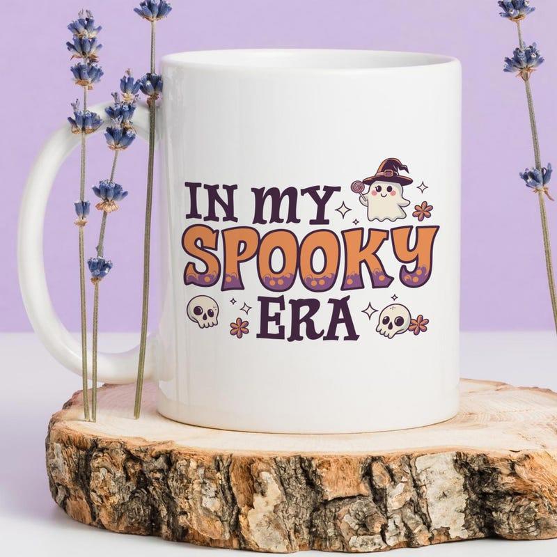 Tailorly White Ceramic 11 oz Mug - In My Spooky Era Playful Cartoon Ghost Wearing Witch Hat Among Skulls And Twinkling Stars Mug
