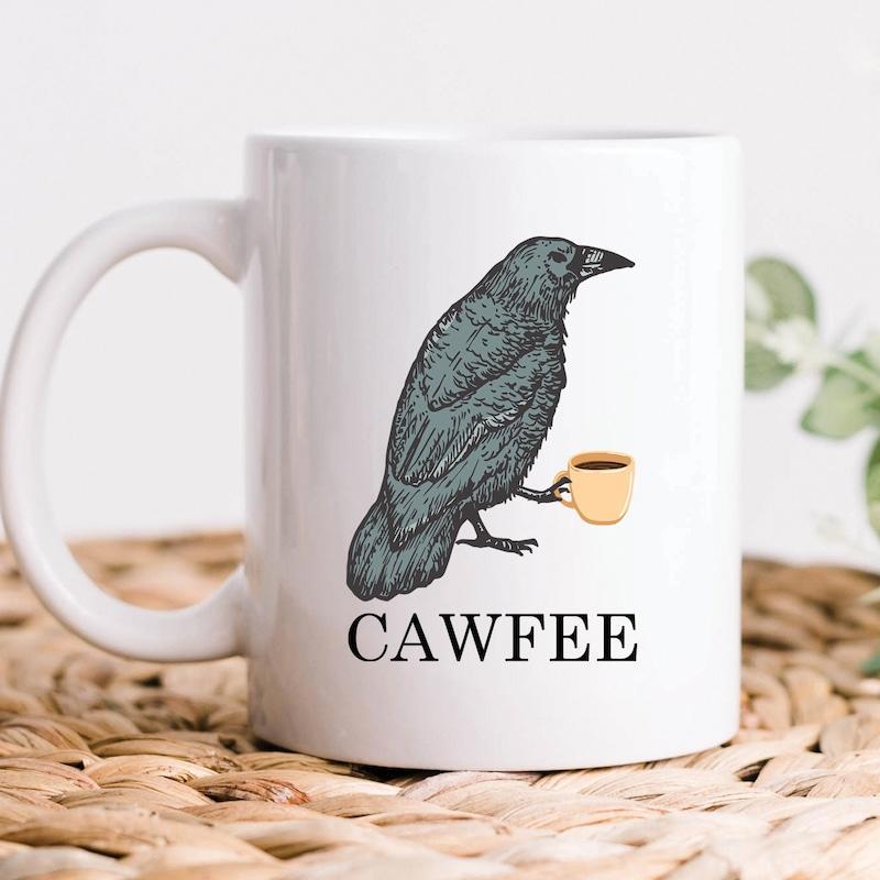 Tailorly White Ceramic 11 oz Mug - Cawfee Dark Feathered Bird Holding A Small Yellow Cup Crow