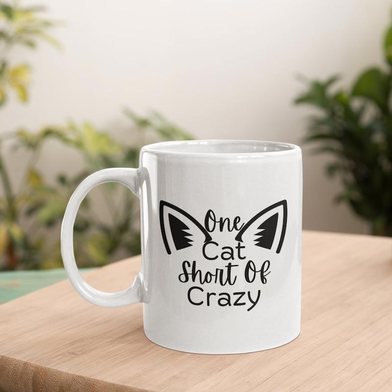Tailorly White Ceramic 11 oz Mug - One Cat Short Of Crazy Symmetrical Pointed Feline Ears With Decorative Script Lettering Within The Center Cat