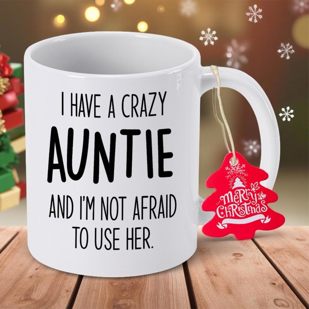 Tailorly White Ceramic 11 oz Mug - I Have A Crazy Auntie And Im Not Afraid To Use Her Clean White Ceramic Vessel Featuring Bold Black Lettering On Wooden Surface
