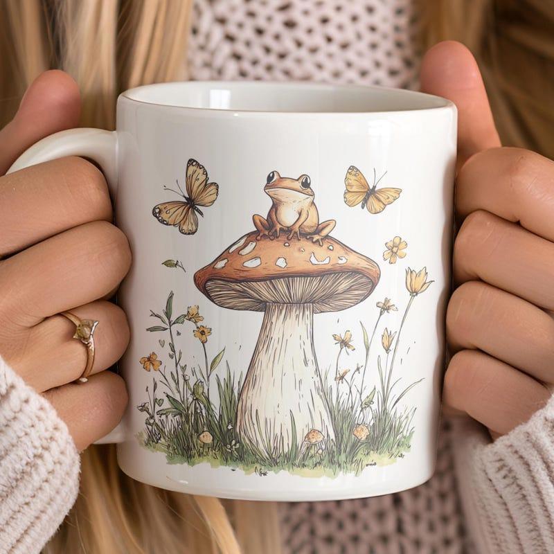 Tailorly White Ceramic 11 oz Mug - Charming Tiny Frog Resting Atop Large Mushroom Among Fluttering Butterflies And Wildflowers Frog