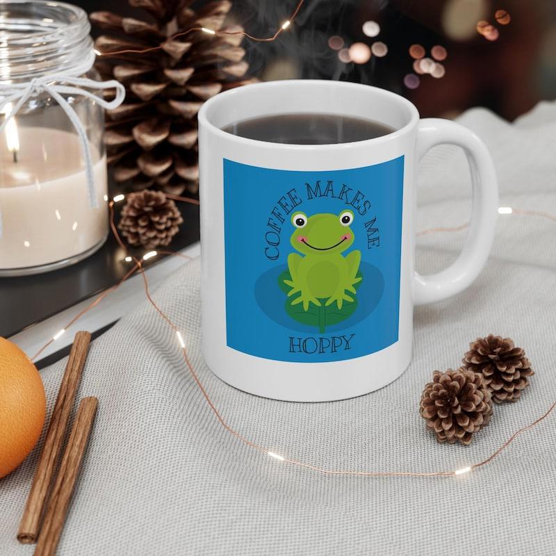 Tailorly White Ceramic 11 oz Mug - Coffee Makes Me Happy Smiling Green Cartoon Character Resting On A Bright Blue Surface Frog