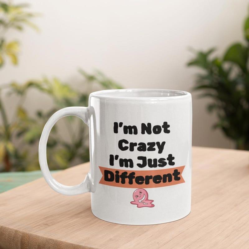 Tailorly White Ceramic 11 oz Mug - I'm Not Crazy I'm Just Different Small Pink Cartoon Snail Resting Below Bold Text On Minimalist