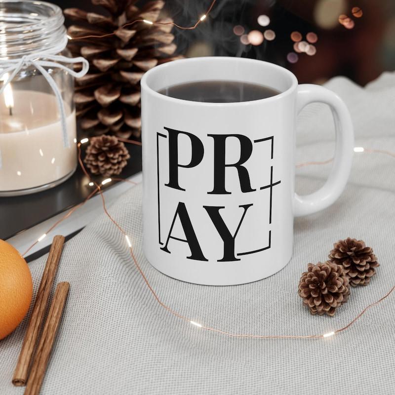 Tailorly White Ceramic 11 oz Mug - Pray Minimalist Black Typography On White Ceramic Placed Among Cozy Holiday Decor Mug