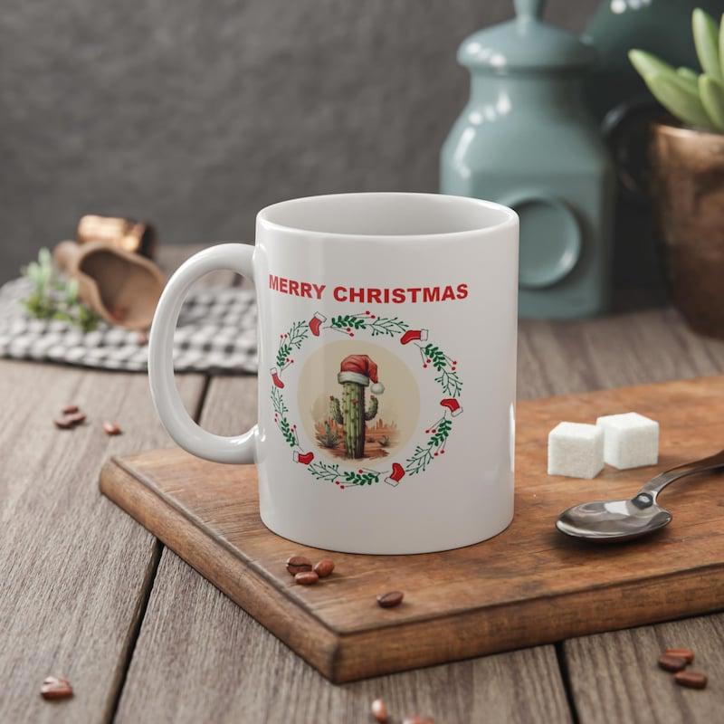 Tailorly White Ceramic 11 oz Mug - Merry Christmas Festive Greenery Wreath Surrounding A Small Potted Desert Plant With Santa Hat Cactus
