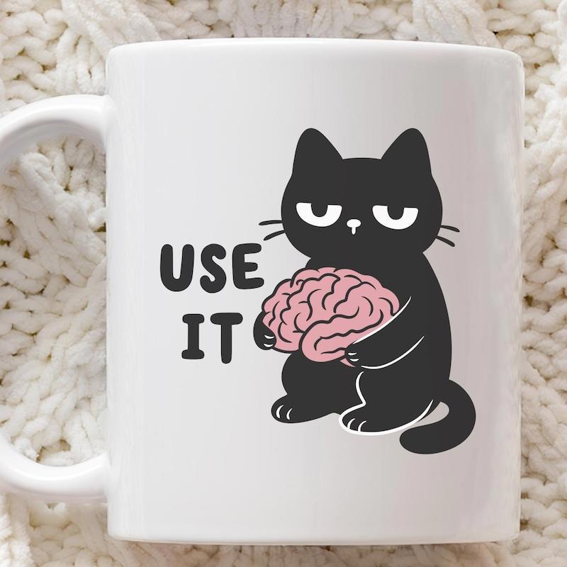 Tailorly White Ceramic 11 oz Mug - Use It Grumpy Black Cat Holding A Pink Brain With A Sarcastic Expression Cat