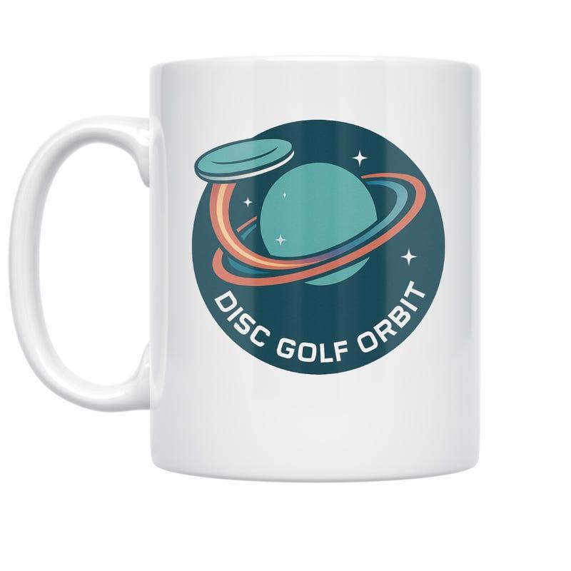 Tailorly White Ceramic 11 oz Mug - Disc Golf Orbit Stylized Planetary Ring With Flying Disc And Twinkling Stars Inside Circular Planet