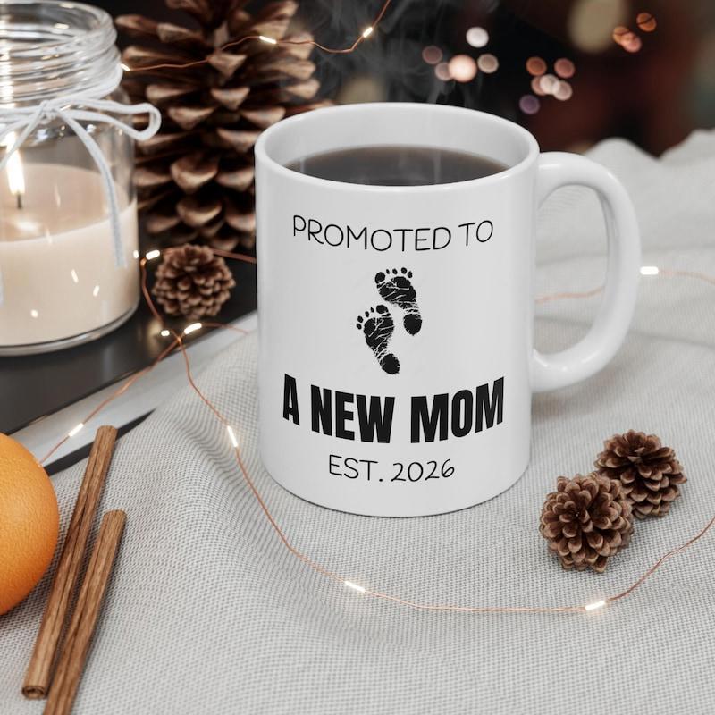 Tailorly White Ceramic 11 oz Mug - Promoted To A New Mom EST 2026 Minimalist Black Baby Footprints Set Among Elegant Modern Script Footprint