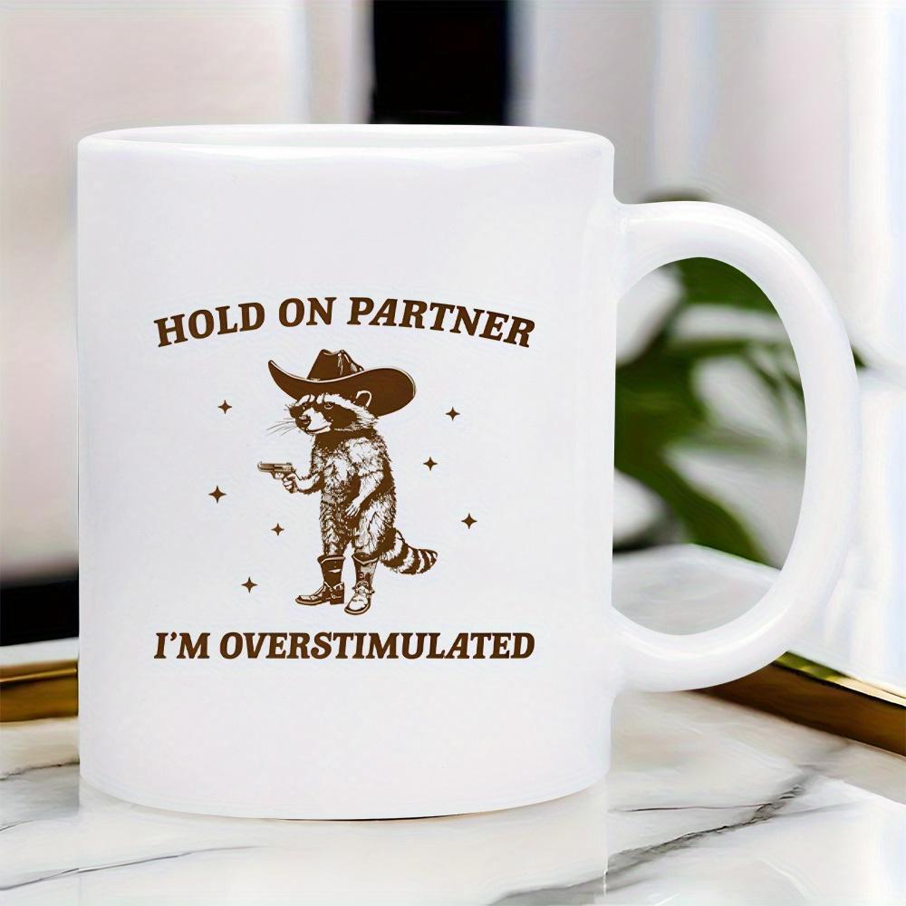 Tailorly White Ceramic 11 oz Mug - Hold On Partner Im Overstimulated Western Style Wearing Cowboy Hat And Boots Holding Small Pistol Raccoon