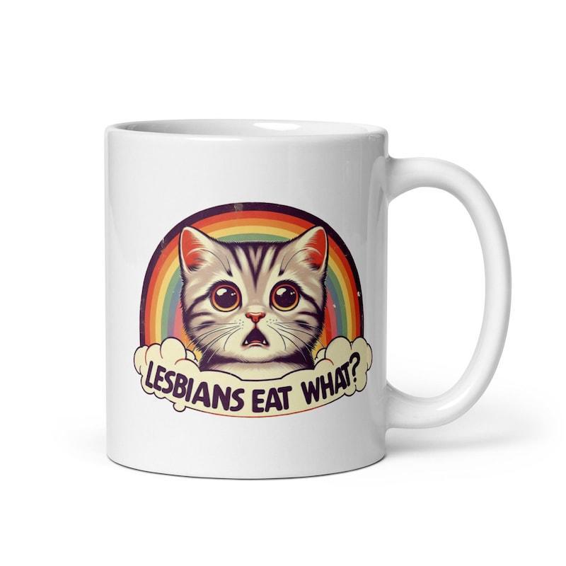 Tailorly White Ceramic 11 oz Mug - Lesbians Eat What Adorable Surprised Kitten With Wide Eyes Under Vibrant Colorful Rainbow Cloud Cat