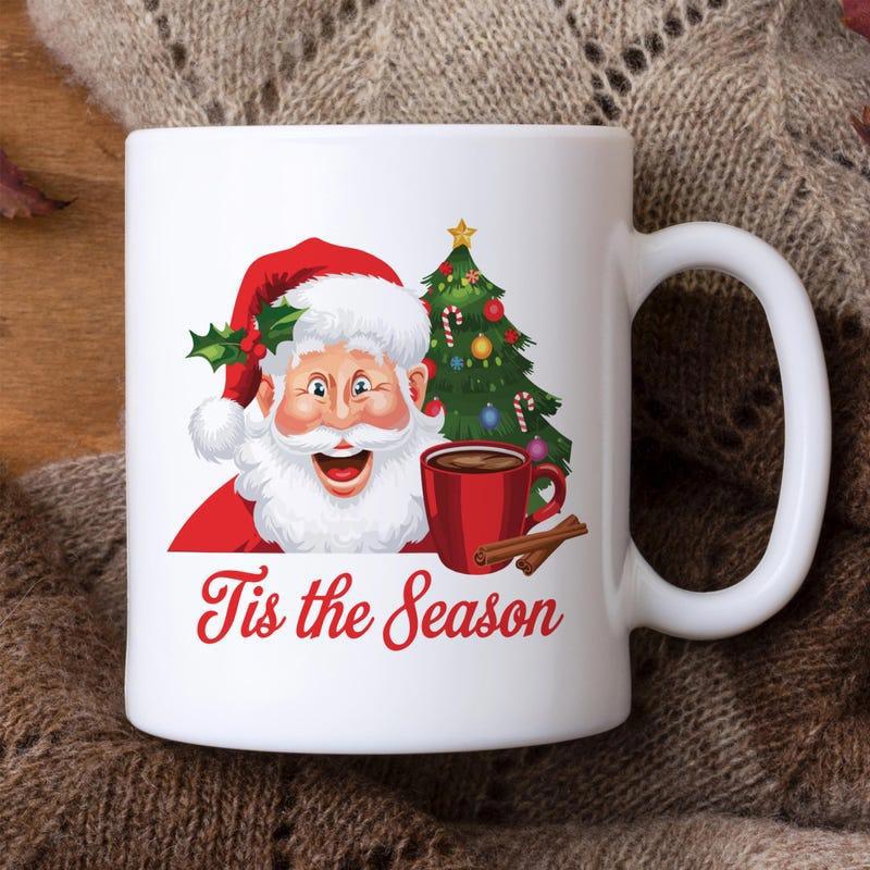 Tailorly White Ceramic 11 oz Mug - Tis The Season Jolly Christmas Character Holding Steaming Mug Beside Decorated Festive Pine Santa Claus