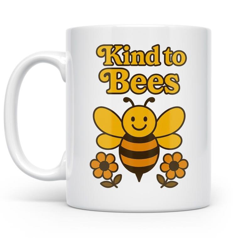 Tailorly White Ceramic 11 oz Mug - Kind To Bees Smiling Yellow Bumblebee With Delicate Wings Hovering Above Two Small Flowers Bee
