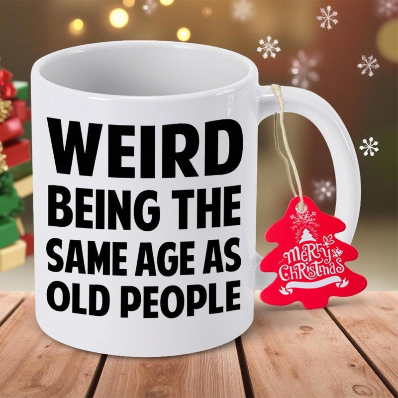 Tailorly White Ceramic 11 oz Mug - Weird Being The Same Age As Old People Classic White Ceramic Material Standing On Rustic Wooden Surface With Festive Decorations
