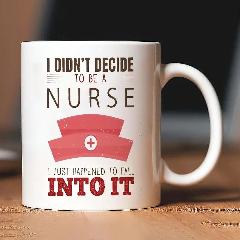 Tailorly White Ceramic 11 oz Mug - I Didn't Decide To Be A Nurse I Just Happened To Fall Into It Pink Stylized Medical Cap With White Cross Emblem Resting Above