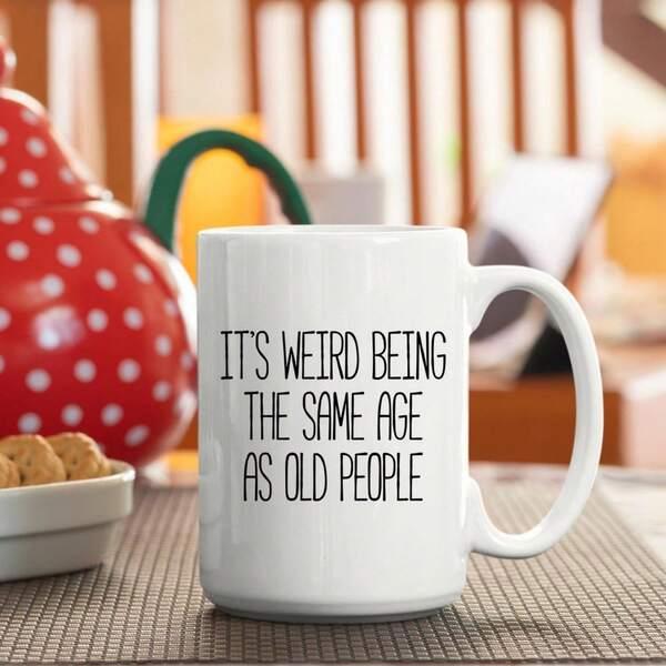 Tailorly White Ceramic 11 oz Mug - It's Weird Being The Same Age As Old People Elegant Ceramic Design Placed On Wooden Table Near Kitchen Items Mug